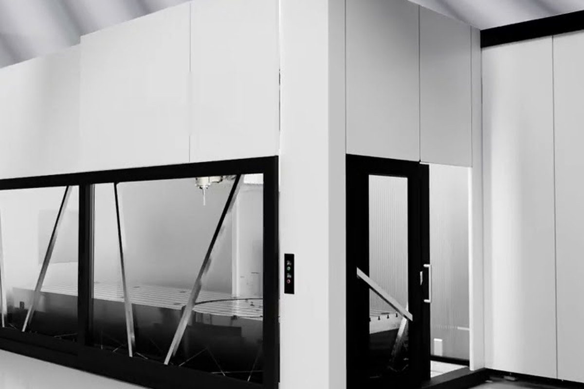 Cerramiento integral llave en mano para un centro de mecanizado de gran formato, con grandes superficies acristaladas y puerta de acceso